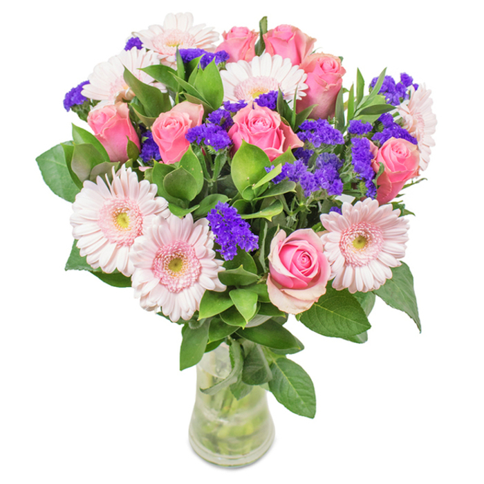 This striking bouquet, designed and delivered fresh from a Tulse Hill florist, exemplifies elegant harmony in floral artistry. Arranged in a pristine glass vase, set against a crisp white backdrop, the bouquet features an inviting mix of approximately 7 to 9 pink roses-some still tightly furled, others just beginning to spiral open, flaunting their classic, romantic form. Intermixed are 5 to 7 pale pink gerberas with large, radiant petals and subtly lighter centers, embodying spring's optimism. Sprays of vibrant purple statice, with their papery, slightly wild texture, thread through the bouquet, infusing each glance with a pop of unexpected colour and lively contrast. A wealth of deep green foliage anchors the arrangement, evoking Tulse Hill's verdant parks and lending a sense of proliferation and woodland freshness. The glass vase, water gleaming and stems displayed, completes the natural look-perfect for delivery as a stunning birthday surprise, an anniversary remembrance, or a thoughtful expression of affection to friends near the Tulse Hill Library or Brockwell Park. This arrangement of soft pinks, vivid purples, and fresh greens offers a visual and emotional celebration, conveying joy, devotion, and elegance in every detail.