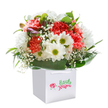 Radiating joy and care from its immaculate white bag, this plush bouquet bursts forth with coral and peach carnations-each petal a note in a song of warmth. Offset by snowy white daisies with lively green hearts, and softened further by the billowy lightness of baby's breath, the effect is both uplifting and deeply sincere. Generous deep green foliage, arched and glossy, encircles the vibrant mass of blooms-its secure cradle reminiscent of quiet corners in Tulse Hill's community gardens. Tucked to the side, delicate purple-tinged buds lend a whisper of mystery and a promise of more blossom to come. Seen without brand markings, the bouquet's charm speaks entirely through its colours and composition, a testament to the artistry and pride of local florists. Crafted for same-day delivery around Tulse Hill, this arrangement shines whether given to brighten a kitchen after errands on Norwood Road, to mark a birthday near Brockwell Park, or simply to bring gentle spring energy indoors. Each stem has been placed with a Florist's touch, conjuring moments of shared happiness and everyday beauty unique to Tulse Hill life.